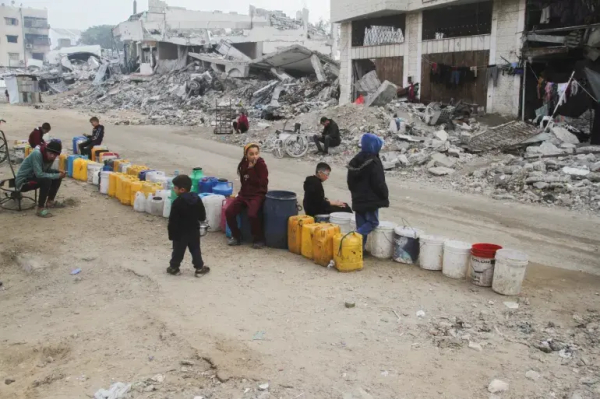 Palestinian children wait to collect water, before a ceasefire set to take effect on Sunday, in Gaza City, January 16, 2025 [Mahmoud Issa/Reuters]