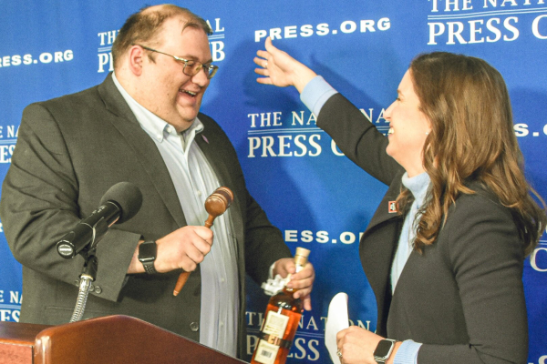 Smiling man and woman in business attire begin to hug