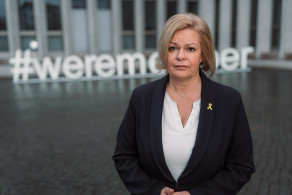 Innenministerin Nancy Faeser vor dem Ministerium mit dem Schriftzug we remember.