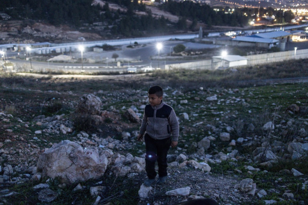 Un ragazzo in piedi su una collina con sullo sfondo la prigione di Ofer, a ovest di Ramallah, il 19 gennaio 2025, in attesa del rilascio dei prigionieri palestinesi come parte di un accordo di tregua tra Israele e Hamas. (Foto: John Wessels / AFP)