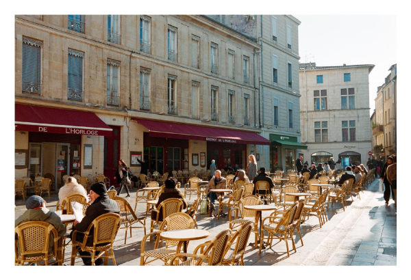 People sitting in the outside area of a french cafe.