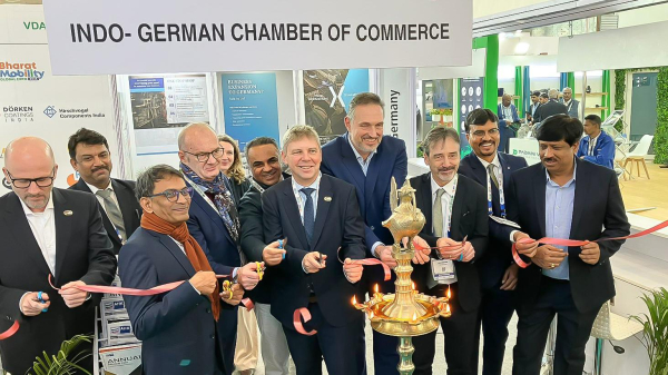 Gruppenfoto u.a. mit Sven Halldorn, Leiter der Grundsatzabteilung des BMDV, und Mitarbeiter des indischen Ministeriums für Schwerindustrie am Rande der Bharat Mobility Global Expo 2025 in Neu Delhi. Die Personen sind im Begriff, einen Messestand zu eröffnen, indem sie ein rotes Band durchschneiden. Auf einem grauen Schild im Hintergrund steht in schwarzer Schrift: "Indo-German Chamber of Commerce".