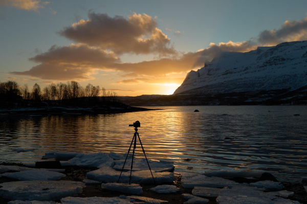 Morning light peeping around the corner of Nova, casting golden hues across Grovfjord and my tripod setup.