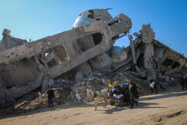 A family rides in a horse-drawn cart past a destroyed mosque in Beit Lahia, northern Gaza Strip, on Jan. 29.