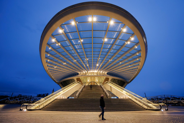 A little silhouette of a man is passing under the giant canopy of the newl Mons train station (Belgium) by architect Calatrava, at blue hour.