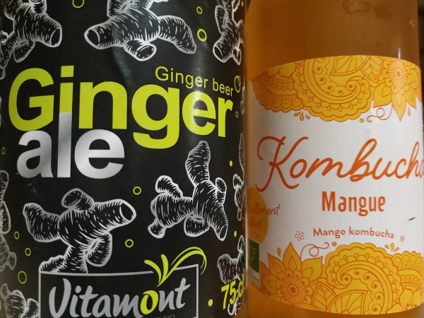 Photo en gros plan d'étiquettes de 2 boissons : une bière au gingembre (Ginger Ale / Ginger Beer) de marque Vitamont, et un Kombucha à la mangue.