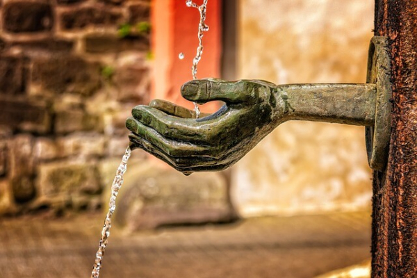 Sculpted hands into which a small stream of water runs.