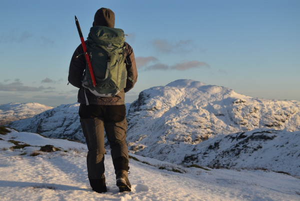 woman on snowy mountains with ice axe