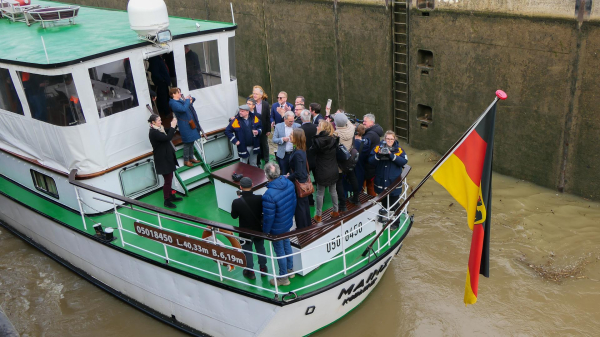 © WSV. Volker Wissing, Petra Berg, Andy Becht und Eric Oehlmann bei der Wiederinbetriebnahme der Schleuse Müden. Sie stehen auf einem Schiff, welches die Schleuse passiert.