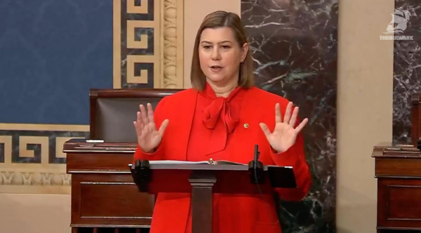 Senator Slotkin in red at podium giving speech