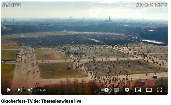 Screenshot von YouTube, Oktoberfest-TV.de: Theresienwiese live um 14:36

Aus einiger Entfernung ist sehr klein rechts eine Bühne zu sehen mit sehr vielen Menschen davor, die etwa 3 Wiesen-Karrees füllen. 