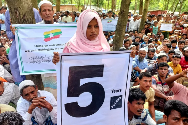 Person in headscarf holding a sign in crowd