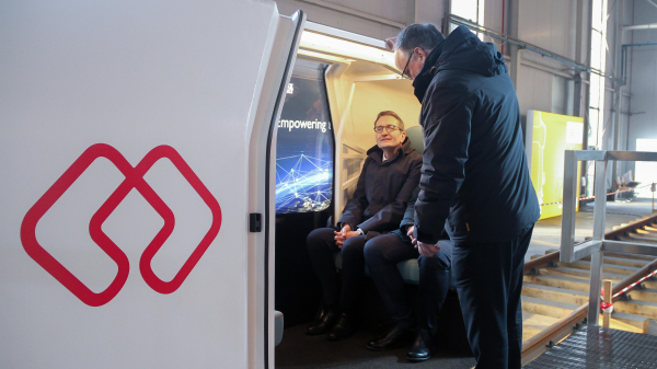 © TH OWL - Thorsten Försterling. Staatssekretär Stefan Schnorr sitzt in der selbst fahrenden Einschienenbahn von MONOCAB. Die Kabinen sind für 4-6 Personen ausgelegt.