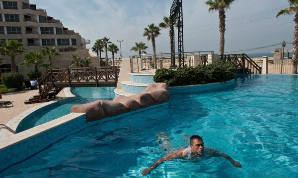 Un preso palestino recién liberado, Atia Abu Fouad, nada en la piscina del hotel Al Mashtal de Gaza en 2011. (Lynsey Addario / Getty Images Reportage)