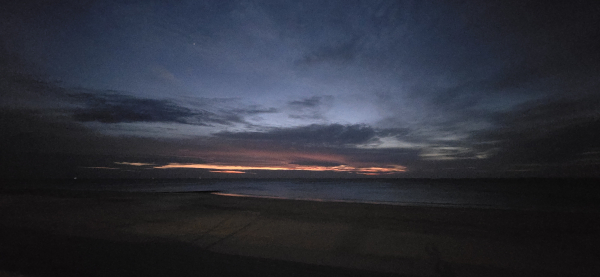 Dramatischer Sonnenuntergang am Strand, mit wilden Wolken