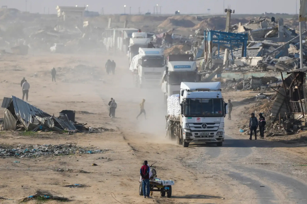 Trucks carrying aid enter Rafah amidst ruins.