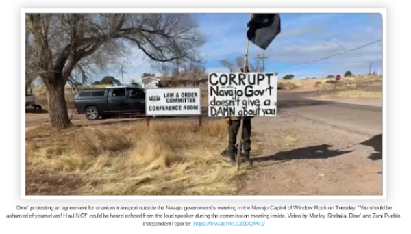 A protestor holding up a sign by the roadside. The sign reads:
CORRUPT
Navajo Gov't
doesn't give a
DAMN about you