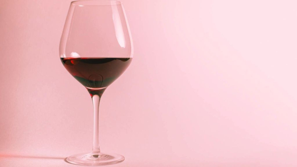 glass of red wine on a pink background