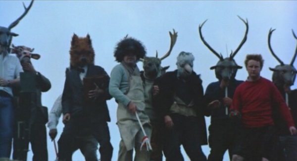 People wearing animals masks, gathered for a ritual.