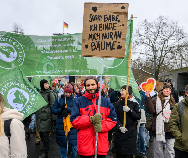 Mann mit Schild: „Sorry Babe, ich binde mich nur an Bäume“. Dahinter die Psychologists for Future und der Reichstag. Beim Klimastreik von Fridays for Future vor der Bundestagswahl 2025, Scheidemannstraße, Berlin, 14.02.2025