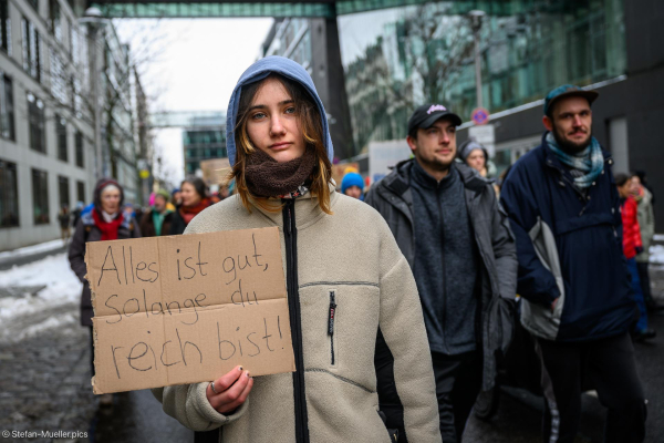 Frau mit Schild: „Alles ist gut, solange du reich bist!“ Zitat aus „Die wilden Kerle“. Beim Klimastreik von Fridays for Future vor der Bundestagswahl 2025, Wilhelmstraße, Berlin, 14.02.2025