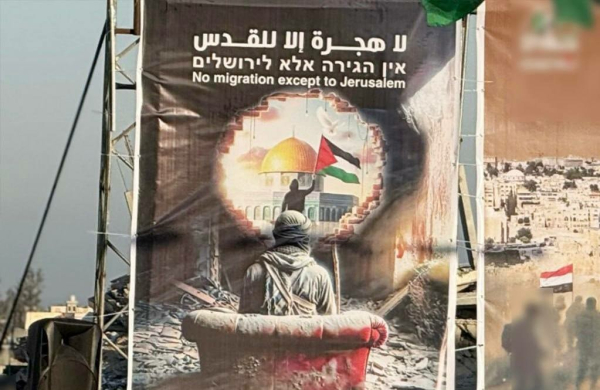 A poster features Arabic, Hebrew, and English text at the top stating, "No migration except to Jerusalem." The central image depicts a person in a war-torn setting sitting on a tattered, red-stained couch with their back turned to the viewer. They are wearing a hooded garment and carrying a rifle. The person is looking through a large hole in a crumbling wall, which frames the Dome of the Rock in Jerusalem. A Palestinian flag is being waved in front of the dome. The ground is covered in rubble, emphasizing the destruction around them. The composition contrasts the destruction in the foreground with the illuminated and intact cityscape in the background.