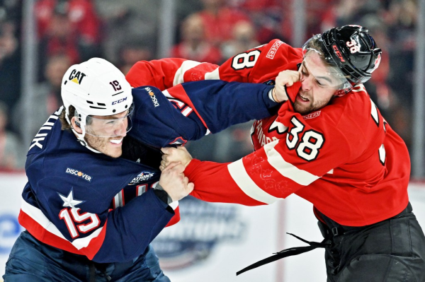 Photo: tow hockey players exchange greetings. Caption The American ice-hockey forward Matthew Tkachuk, left, brawls with his Canadian counterpart, Brandon Hagel, during the 4 Nations Face-Off game at the Bell Centre in Quebec. Team USA won 3-1