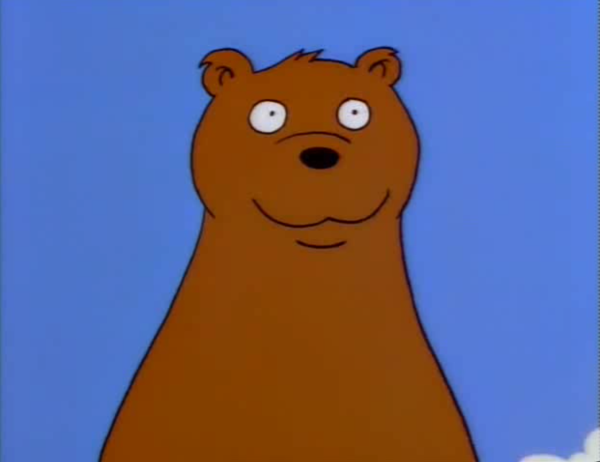 A still from an episode of The Simpsons, depicting a standing bear looking forwards with a faint smile