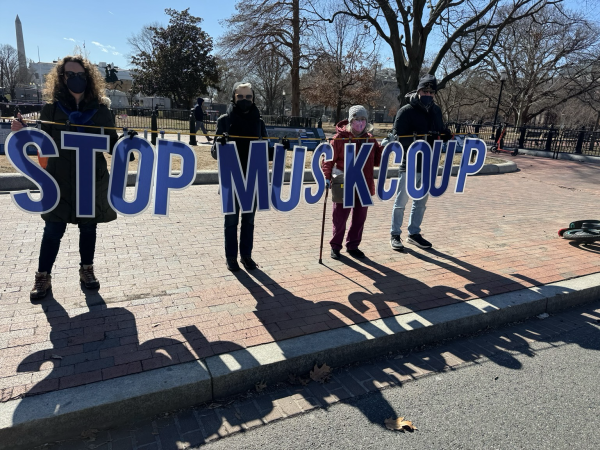 Four activists holding long sign that spells out Stop Musk Coup