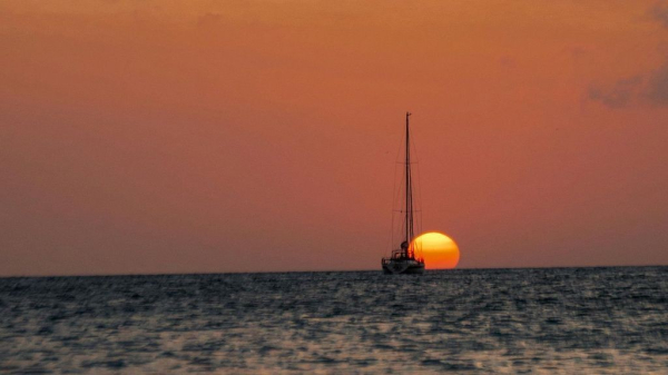 sailing ship with a setting sun in the background