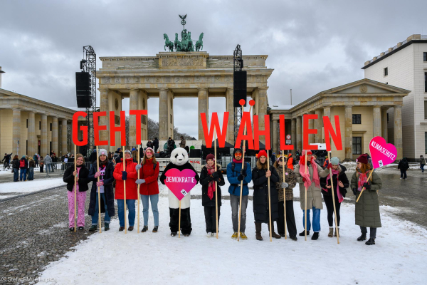 Teilnehmer*innen vom WWF mit Schildern „Geht wählen“ beim Klimastreik von Fridays for Future in Berlin. Brandenburger Tor, 14.02.2024