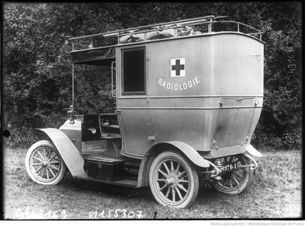 A black and white photo of a vehicle with no doors and an open top to hold equipment. On the side it says RADIOLOGIE, accompanied with a Red Cross. 