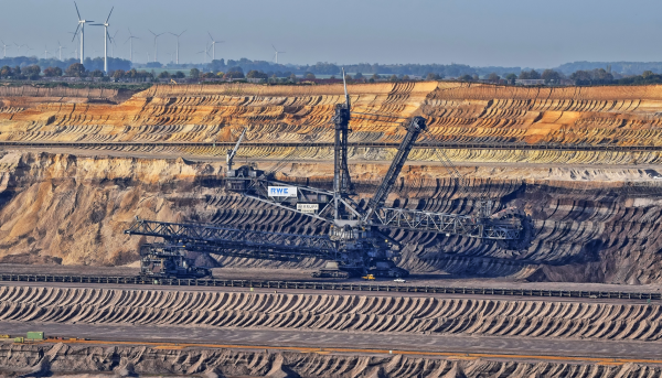 Windräder hinter einem gigantischem Tagebau mit Riesenbagger