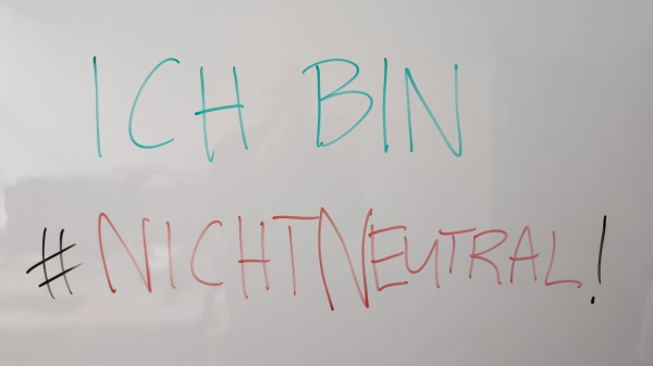 Foto von einem Whiteboard mit bunter Schrift:

Ich bin #nichtNeutral!