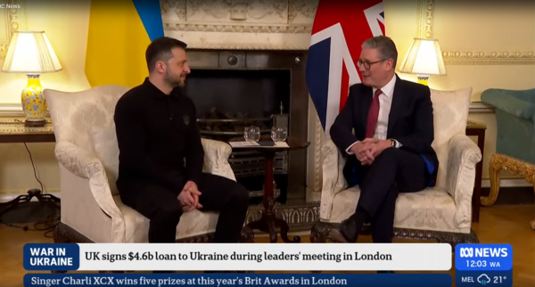 Ukraine President Volodymyr Zelenskyy and UK Prime Minister Keir Starmer sitting and talking with flags of both countries in background, as broadcast on Australia's ABC News 24.