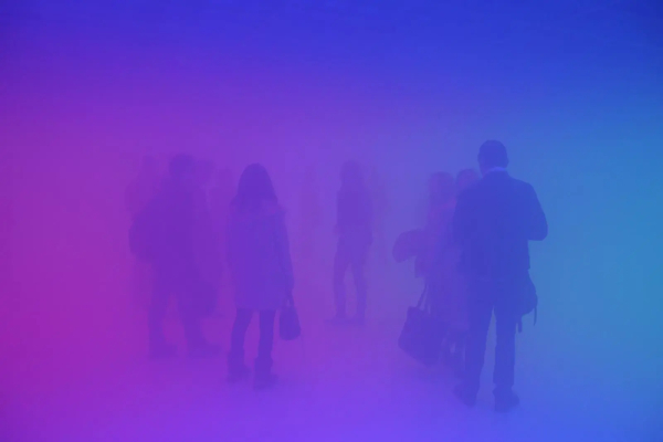 Figures standing in an empty gallery, semi-obscurred by a foggy glow of pink and blue light.