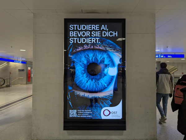 KI-Studiengangswerbung einer Fachhochschule: «Studiere KI bevor sie dich studiert» über einem künstlich blauem Riesenauge