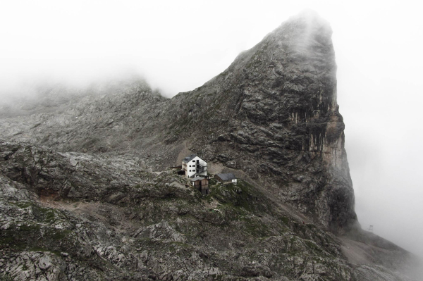 Das Riemannhaus im Steinernen Meer im Nebel. Rund um das Haus nur Felsen.