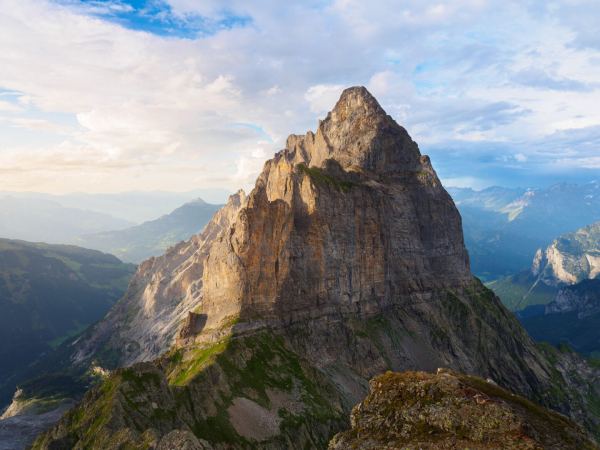 Zu sehen ist das Gstellihorn mit einer Höhe von 2.855m im Sonnenuntergang, bei dem es mit goldenem Licht angestrahlt wird.