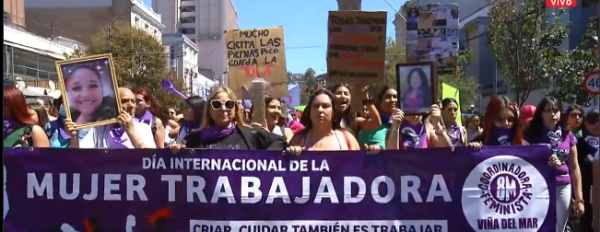 Screenshot of a huge protest in Valparaíso, with women marching behind a purple banner reading INTERNATIONAL WORKING WOMEN'S DAY