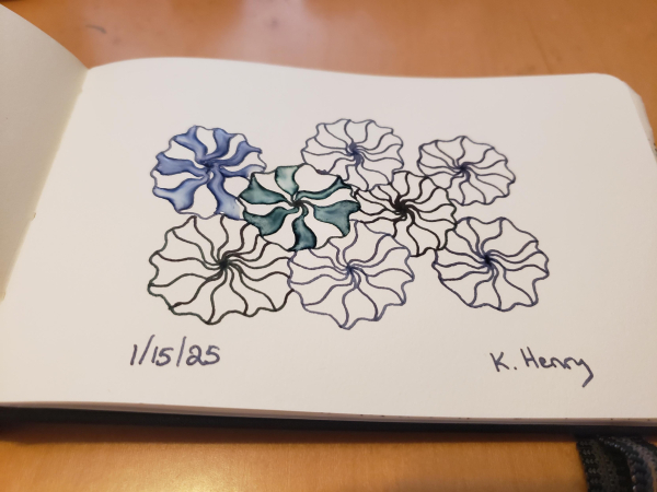 Hand drawn generative/procedural art in ink on an open page of my sketchbook. The abstract pattern looks a bit like a bunch of flowers.