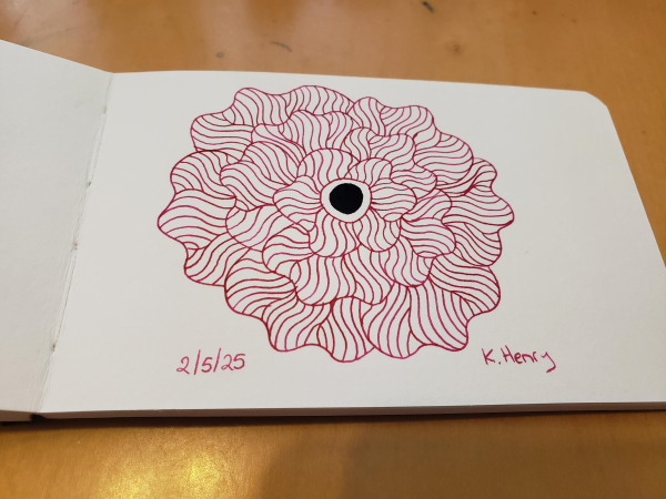 Hand drawn generative/procedural art in ink on an open page of my sketchbook. The abstract pattern looks a bit like a fully bloomed flower.