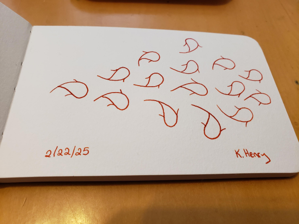 Hand drawn generative/procedural art in ink on an open page of my sketchbook. The abstract pattern looks a bit like a bunch of little fish in the pattern of a bigger fish.