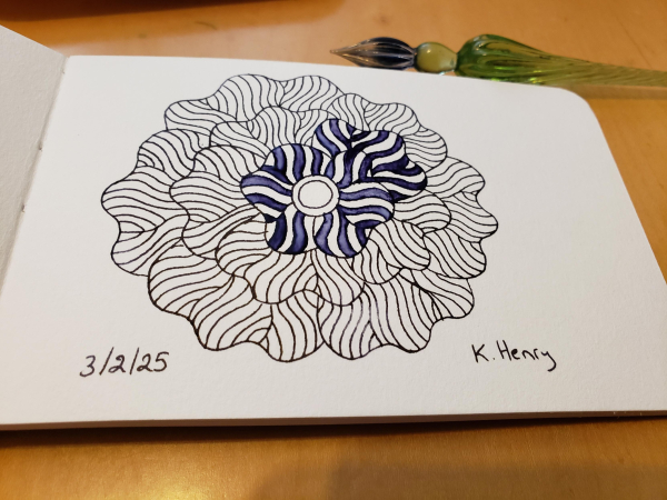 Hand drawn generative/procedural art in ink on an open page of my sketchbook. The abstract pattern is floral. My glass dipping pen is next to my sketchbook.