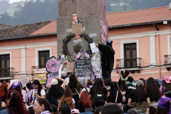 Women in Quito, El Salvador place placards on a monument in the centre of town.