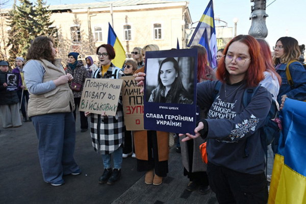 Women in Kharkiv carry flags and placards.