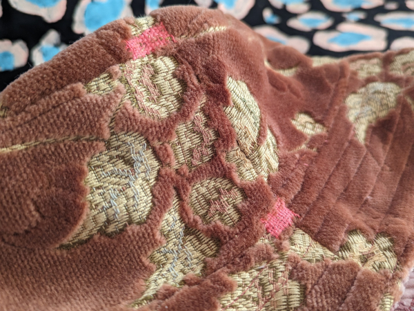 Two patches of visible pink mending on the side of the hat. 